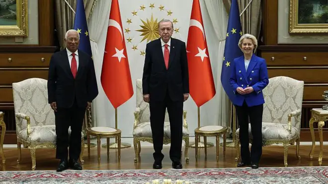 Cumhurbaşkanı Erdoğan, von der Leyen ve Costa Beştepe'de kameralara poz veriyor. Erdoğan ortada, sağında Costa, solunda von der Leyen olmak üzere üç lider de ayakta duruyor. Arkalarında Türk ve AB bayrakları var.