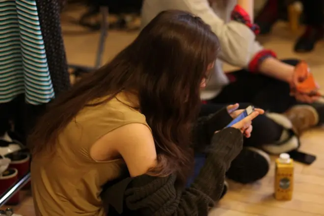 یوه جلکۍ مبایل ته ګوري