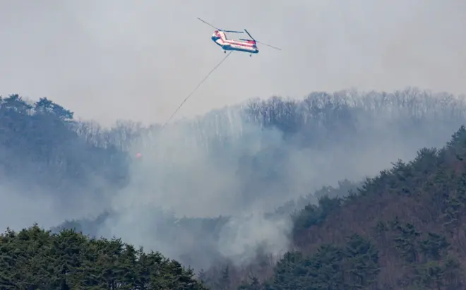 구곡산 일대에서 산불 진화 헬기가 진화 작업을 벌이고 있다