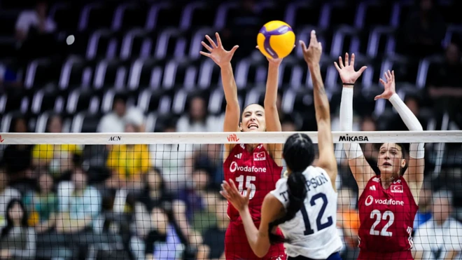 Türkiye A Milli Kadın Voleybol Takımı'nın savunma anında çekilen bir fotoğrafı. İki milli voleybolcu filenin arkasında blok yapmaya çalışıyor