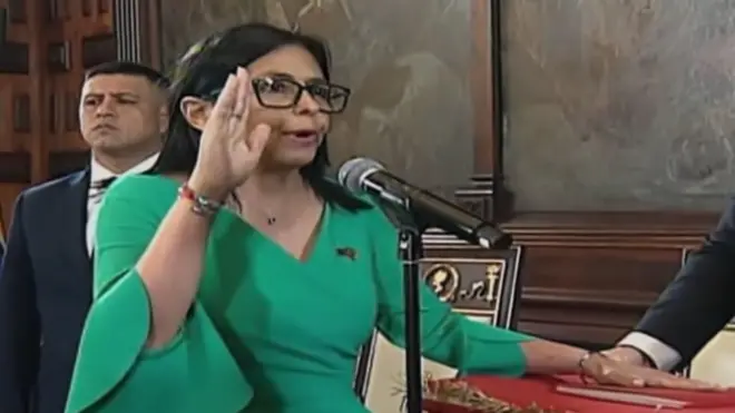 Delcy Rodríguez, con vestido verde y la mano alzada, jura su cargo de presidenta encargada de Venezuela el lunes 5 de enero de 2026