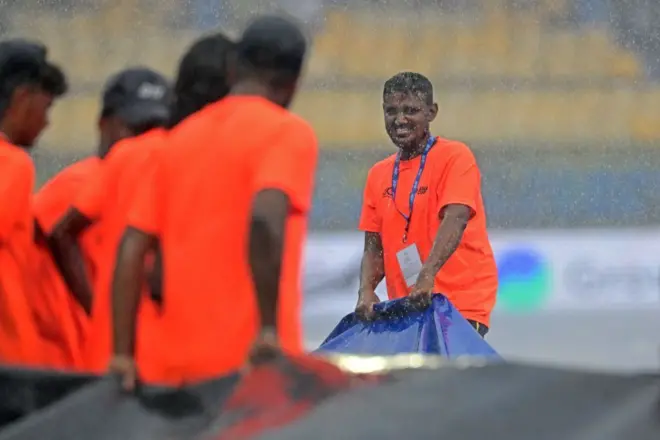 Ground staff cover the field as rain delays the start of the Asia Cup 2023 Super Four one-day international (ODI) cricket match between Sri Lanka and Pakistan at the R. Premadasa Stadium in Colombo on September 14, 2023