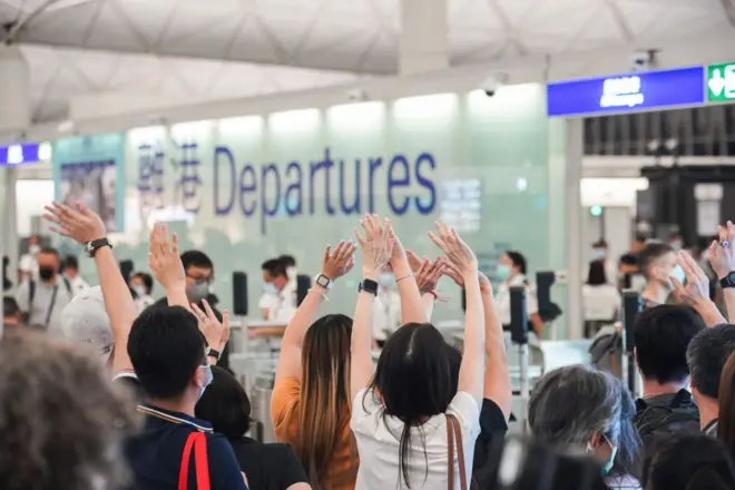 (2021/07/18) 香港机场的离港闸口前，一群人挥手送别。