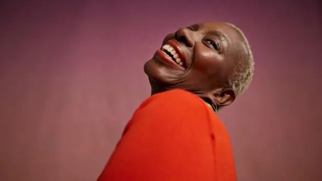 Femme riant sur fond de pêche dans un studio