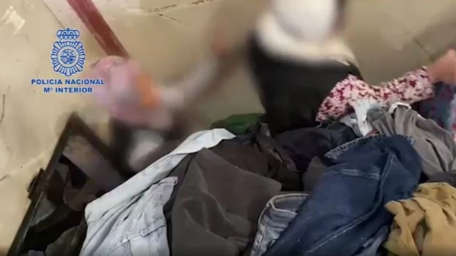 Amashusho yagaragaje abakozi barimo kurekurwa bava mu cyumba gihishe inyuma y'ibirundo by'imyenda