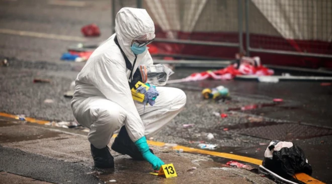 Liverpool'daki olay sonrası tam boy beyaz bir kıyafet giyen eldivenli polis delil topluyor