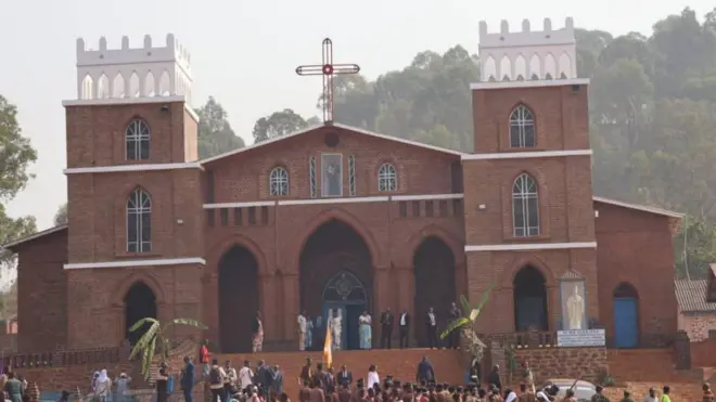 Isengero ya Paruwasi Mugera uyirabiye imbere y'ubwinjiriro, iboneka n'iminara yayo ibiri, hari abantu bahagaze 