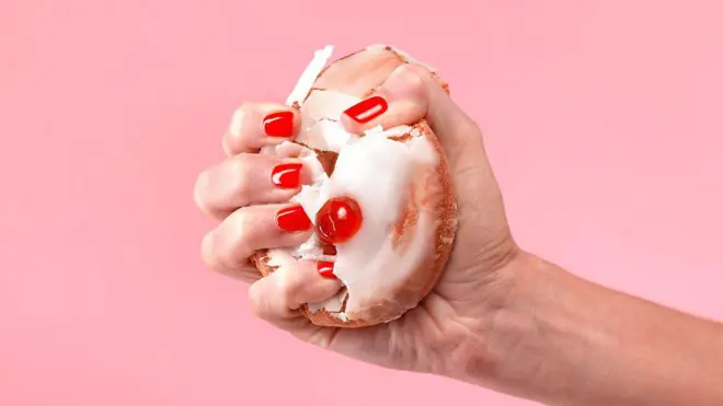 Mano de mujer apretando con fuerza un bizcocho