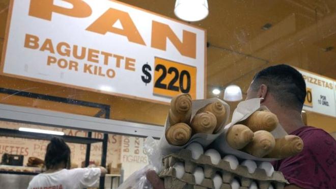 A man buying baguettes for 220 Pesos each