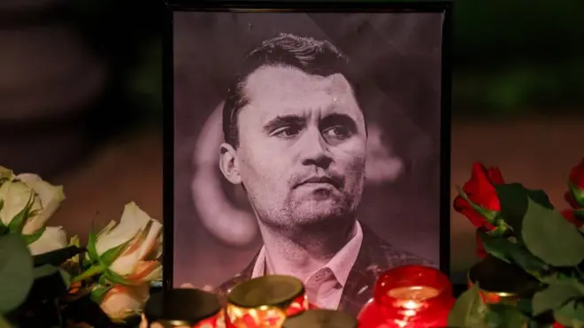Candles stand in front of a photo of the deceased US political activist Charlie Kirk during a vigil