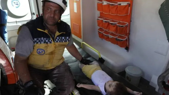 एक बच्चे के पास मौजूद बचाव कर्मी