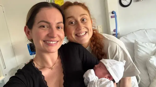 Na zdjęciu Georgia trzyma noworodka, obok niej stoi Daisy.