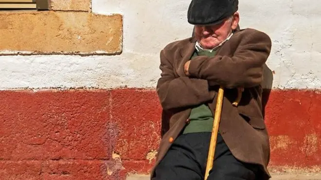 رجل أسباني يأخذ قسطا من الراحة أو غفوة وهو يجلس بجوار أحد المنازل