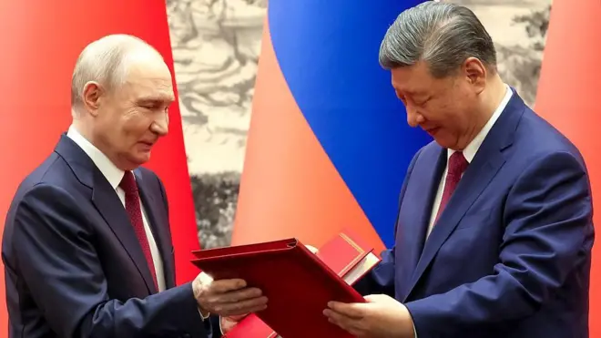 Путін і Сі обмінюються папками на фоні прапорів Росії та Китаю