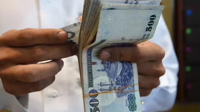 سعودي يحمل ريالات سعودية