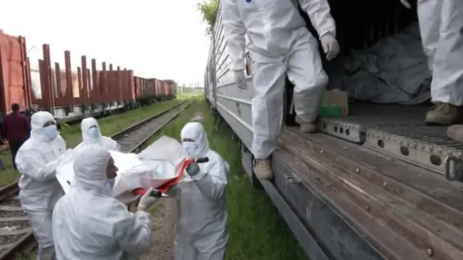 Украинские военные складывают тела в специальный поезд.