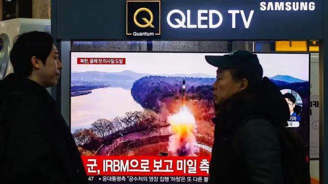 Люди смотрят репортаж о запуске Северной Кореей баллистической ракеты