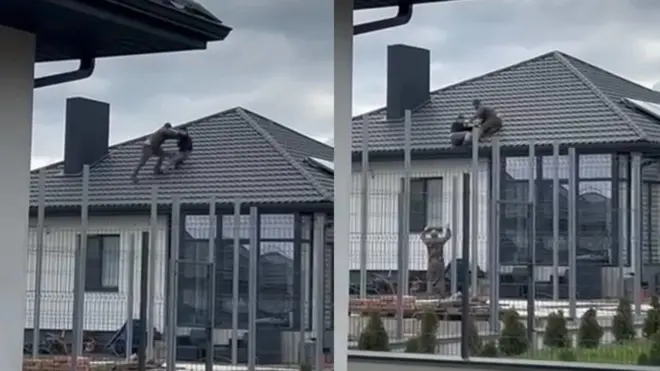 На кадрах із відео видно, як чоловік із іншим чоловіком у формі б'ються на даху, а потім падають разом, і там їх допомагає зловити інший чоловік