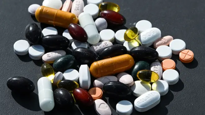 A collection of pills and tablets against a plain background