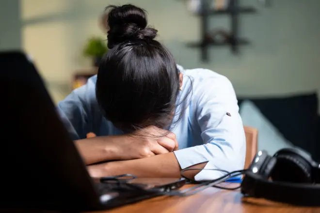 Stock photo of woman resting head on desk