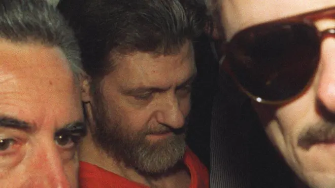 हेलेना, मोंटाना येथील फेडरल कोर्टात उनबॉम्बरला घेऊन जाताना. हा फोटो 4 एप्रिल 1996 चा आहे. 