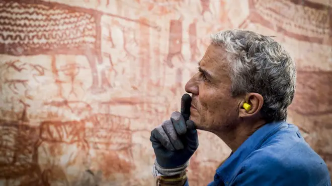 Carlos Castaño observando varios de los miles de dibujos de arte rupestre en Chibiriquete.