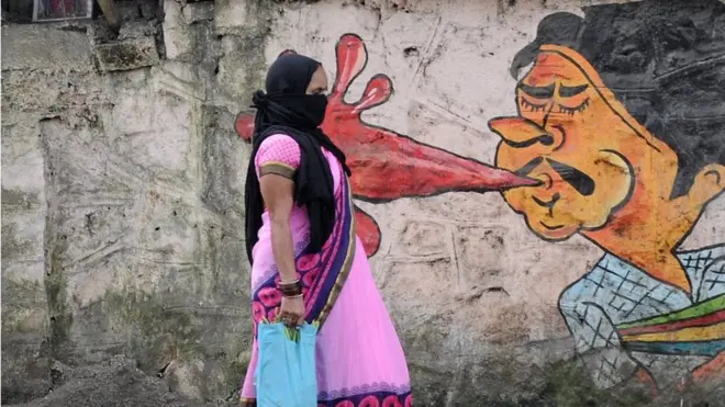 A woman walks past a graffiti in Mumbai. Municipal corporation is creating awareness about the dangers of spitting in public places through graffiti.
