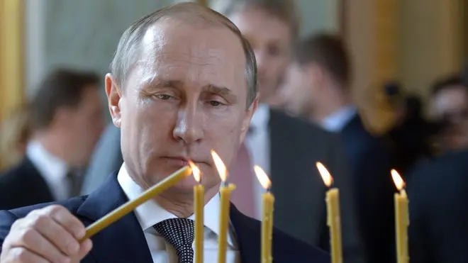 A picture of Vladimir Putin lighting candles