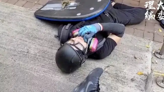 受枪伤的学生倒在地上，等候救援。