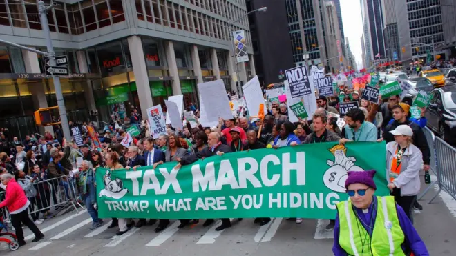 示威者质疑特朗普迟迟不愿意公开税务纪录，是不是因为有些不可告人的秘密。