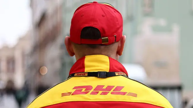 身穿黄色和红色品牌外套、头戴红色帽子的 DHL 男员工
