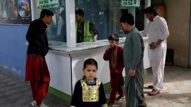 Des hommes et des enfants devant un poste de garde.