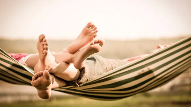 Os pés de uma mãe e filha numa rede