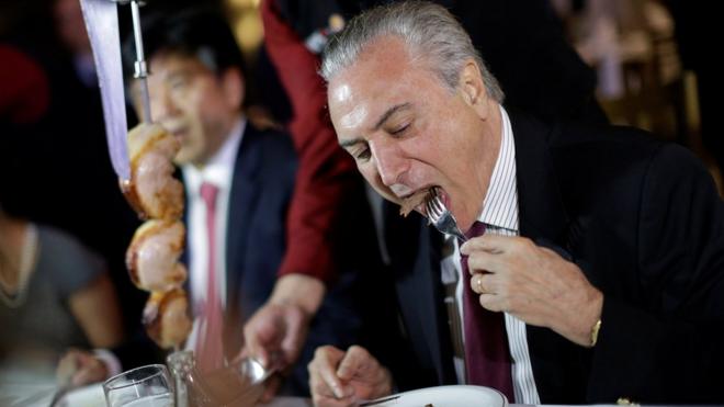Brazil's President Michel Temer eats barbecue in a steak house after a meeting with ambassadors of meat importing countries of Brazil, in Brasilia, Brazil March 19, 2017.