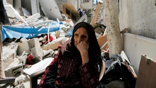 امرأة غزية أمام منزلها المدمّر 