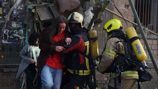 Equipos de emergencia socorren a los residentes de los edificios impactados por el ataque.