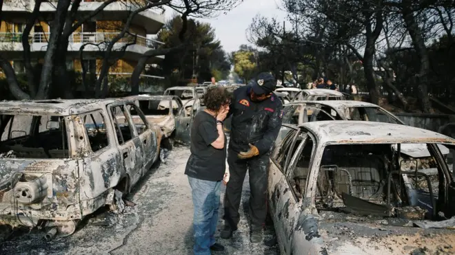 A woman reacts as she tries to find her dog, following a wildfire at the village of Mati, near Athens, Greece July 24, 2018