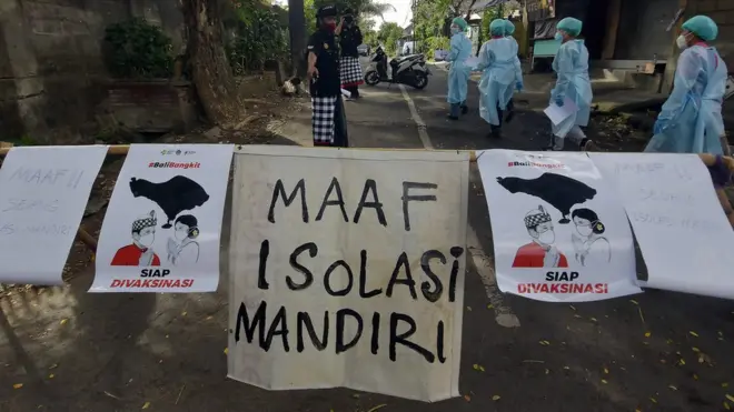 Petugas kesehatan memasuki area isolasi mandiri saat melakukan pendataan bagi warga yang terpapar COVID-19 di Banjar Terunasari, Desa Dauh Puri Kaja, Denpasar, Bali, Kamis (01/07).