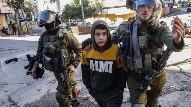 سربازان اسرائیلی در حال بازداشت یک پسر جوان در الخلیل در سال ۲۰۲۲