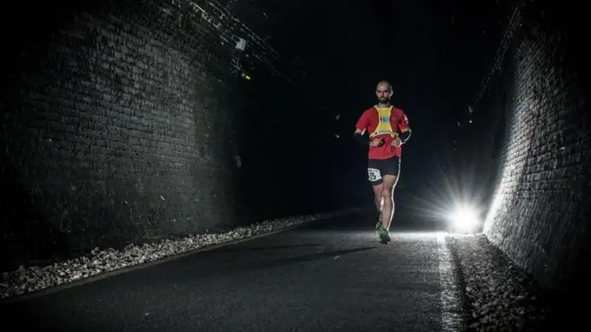 مایک رافان، یکی از معدود دوندگانی که این مسابقه را به پایان رسانده، مسابقه تونل را اینگونه خلاصه میکند: «دوندگان از یک سر تونل به سر دیگر آن میدوند و دور میزنند و بر میگردند و دوباره همین کار را صد بار تکرار میکنند»