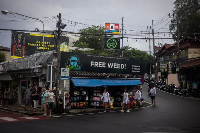 People walk in front of cannabis-related advertising signs, in Phuket, Thailand, August 12, 2023. REUTERS/Jorge Silva