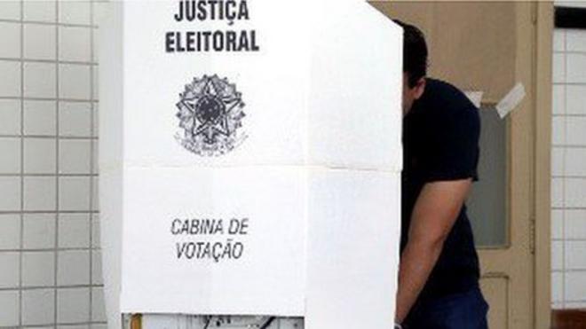 Pessoa vota em cabine de votação