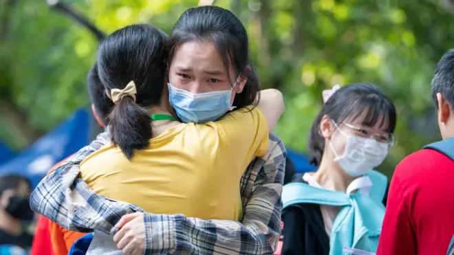 A student hugs her teacher before entering an exam site during the 2020 National College Entrance Exam