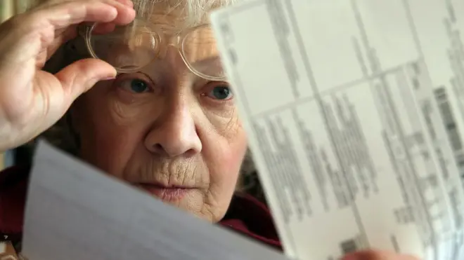 Женщина читает квитанцию по ЖКУ