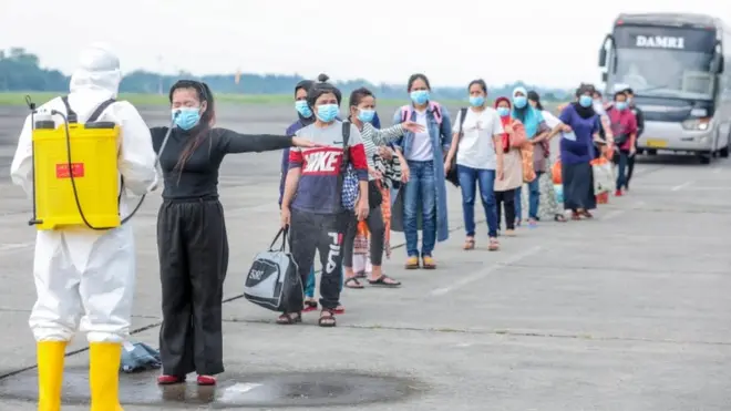 Tenaga kerja menjalani penyemprotan di Medan, setibannya dari Malaysia.