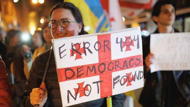 Девушка с плакатом на акции протеста в Тбилиси. 21 февраля 2026 года