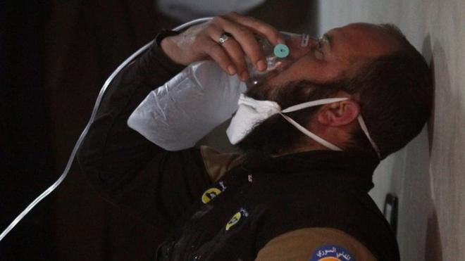 A man breathes through a gas mask after a chemical attack in Syria