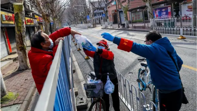 Volunteers deliver medicines to a resident on February 29, 2020 in Wuhan, Hubei Province of China