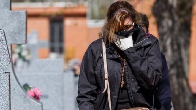 A woman arrives for the burial of a COVID-19 coronavirus victim at the Fuencarral cemetery in Madrid