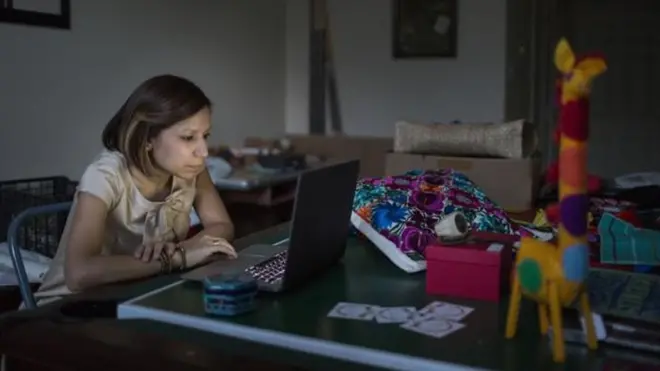 Perempuan memandang laptop.